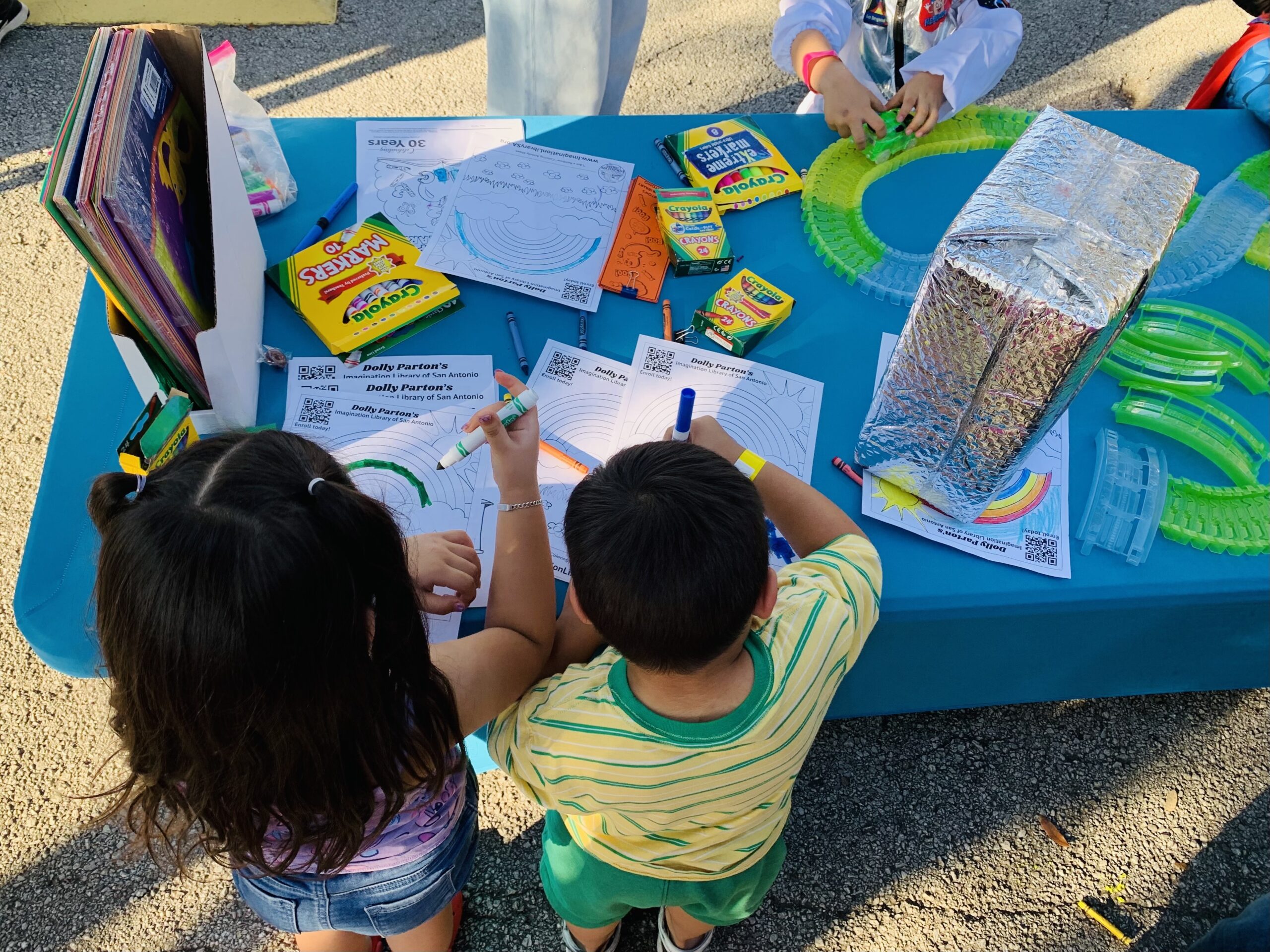 Children reading and coloring at an ILSA community event